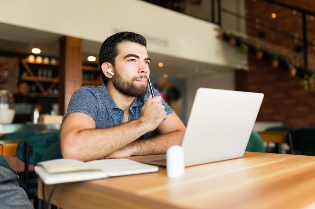 It's important to apply your discernment to every piece of generative AI content. In this image, a writer sits at his laptop thinking about what he's going to write.